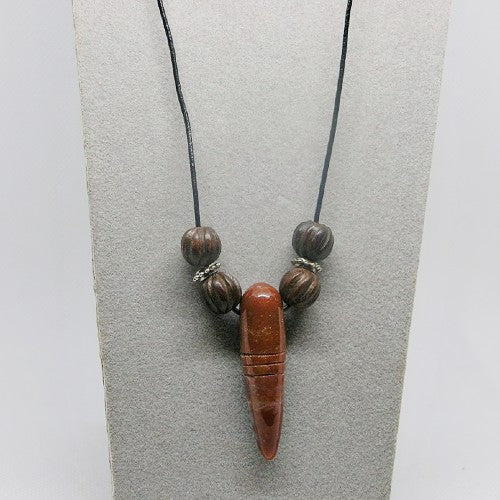 Necklace with wooden beads and stone pendant on a gray background