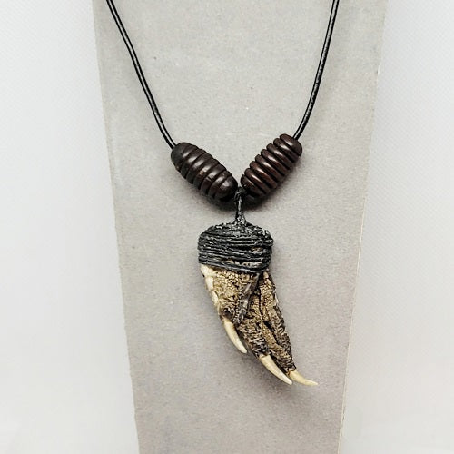 Necklace with an alligator claw pendant on a gray background