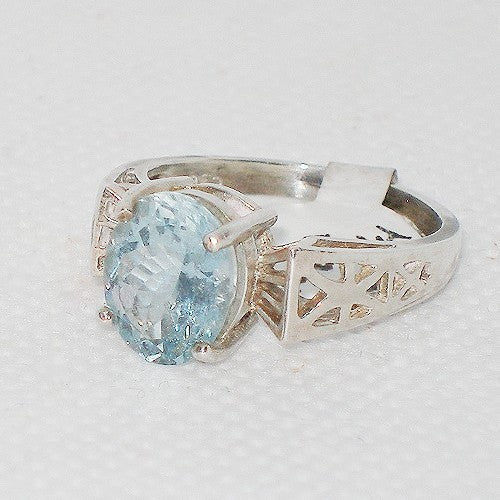 Silver ring with a blue gemstone on a light gray background