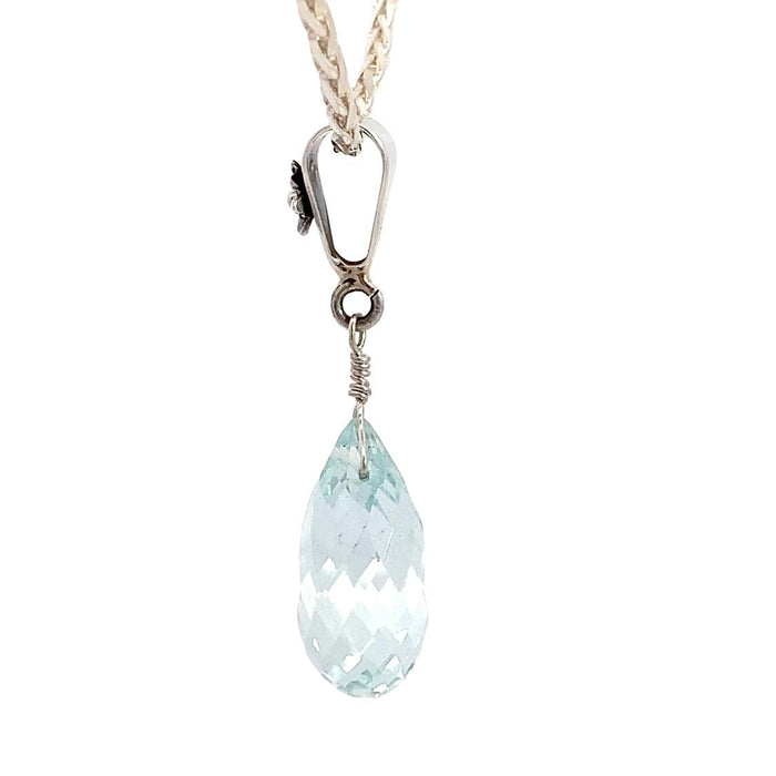 a sterling silver pendant featuring an aquamarine briolette pendant with a floral inspired bail on a silver chain on a white background side view