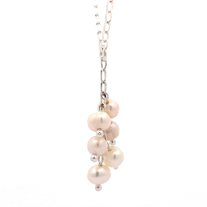 photo of a silver "Y" necklace with six pink pearls on a white background side view