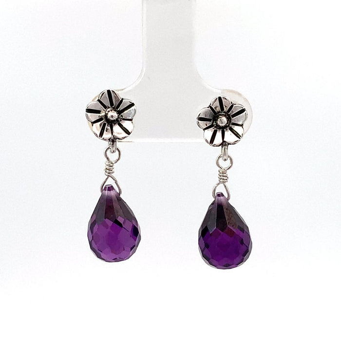 photo of a pair of amethyst briolettes topped with a flower stud in silver suspended on a white background