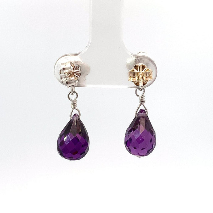 photo of a pair of amethyst briolettes topped with a flower stud in silver suspended on a white background rear view