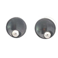 photo of a pair of black and silver circle shaped stud earrings on a white background