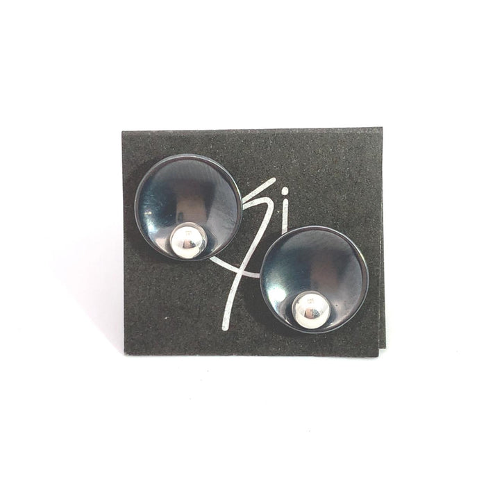 photo of a pair of black and silver circle shaped stud earrings on a white background placed on the artists card