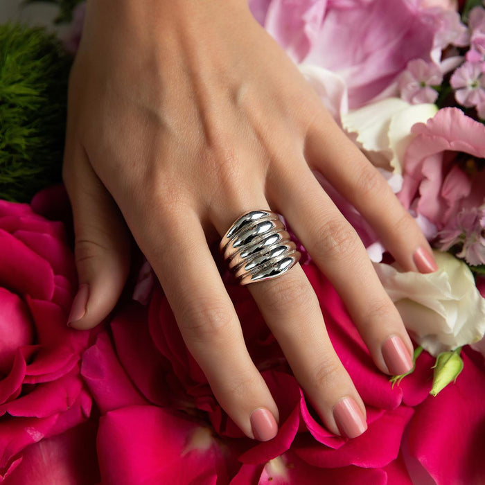 Sterling Silver Ring-Artisan Made  Tapering Wide Ribbed Design on hand with flower background