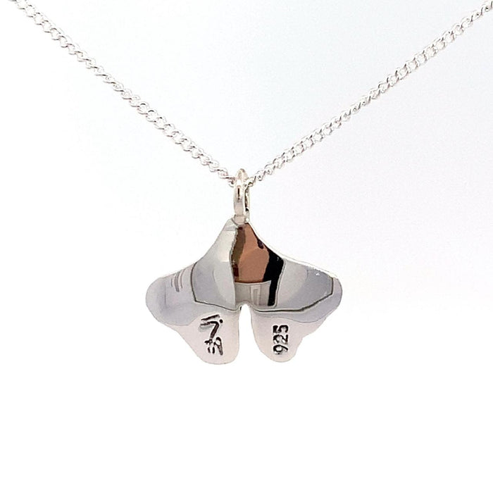 photo of a silver ginkgo leaf pendant on a chain taken on a white background rear view