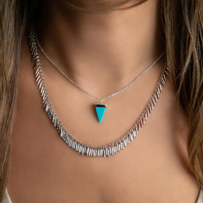 photo of a brunette model wearing a silver turquoise necklace and a silver fringe style necklace