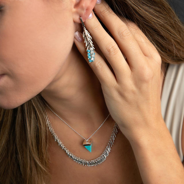 photo of a brunette model wearing a silver turquoise necklace and a silver fringe style necklace
