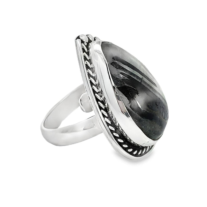photo of a modern silver ring with a oval pink gemstone on a white background side view