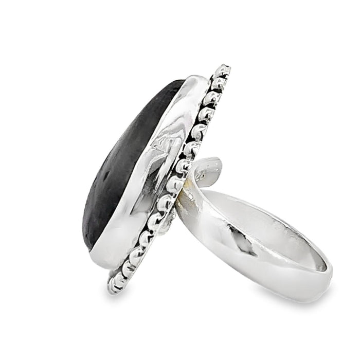 photo of a modern silver ring with a oval pink gemstone on a white background side view