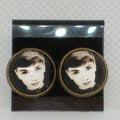 Pair of earrings with a portrait design on a gray background
