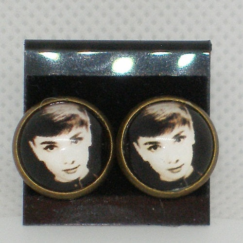 Pair of earrings with a portrait design on a gray background