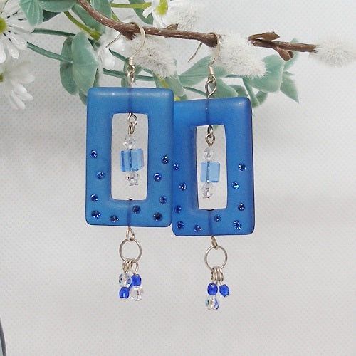 Blue square earrings with beaded details on a white background