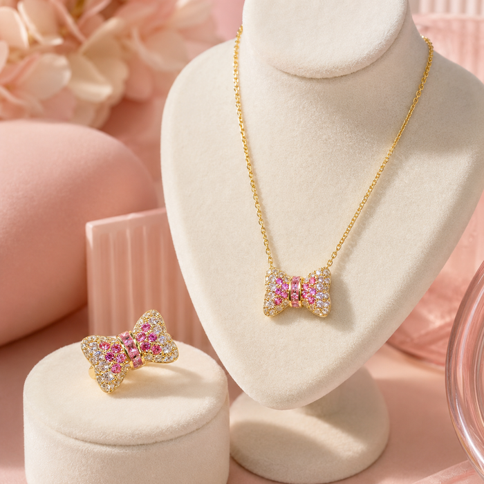 Cute, sparkling, and beautifully feminine, the Blush Bow Set is made for someone who loves soft romantic jewelry with a playful luxe touch. Designed with a crystal-studded bow necklace and matching ring, this set brings a sweet pink glow that feels perfect for everyday styling, special moments, or thoughtful gifting.