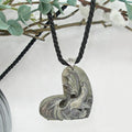 Necklace with a carved heart-shaped stone pendant on a white background