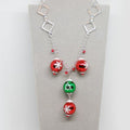 Necklace with red and green beads on a gray card