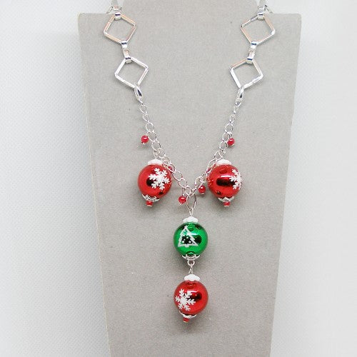 Necklace with red and green beads on a gray card
