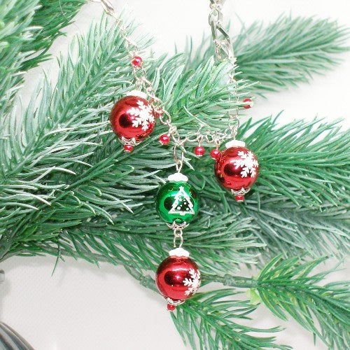 Decorative Christmas ornament necklace with red and green baubles on a branch.