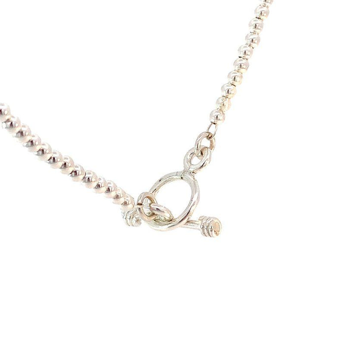 photo close up shot of a silver bead necklace