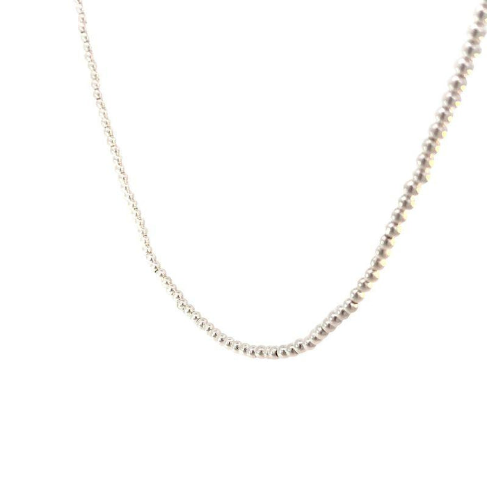 photo close up shot of a silver bead necklace