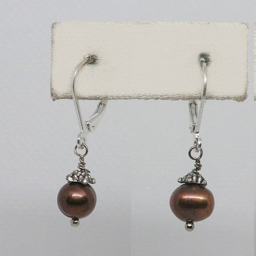 Pair of earrings with brown beads on a white card