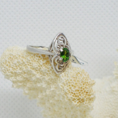 Silver ring with a green gemstone on a white background