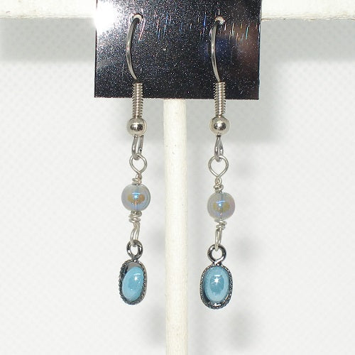 Silver earrings with light blue stones on a white background