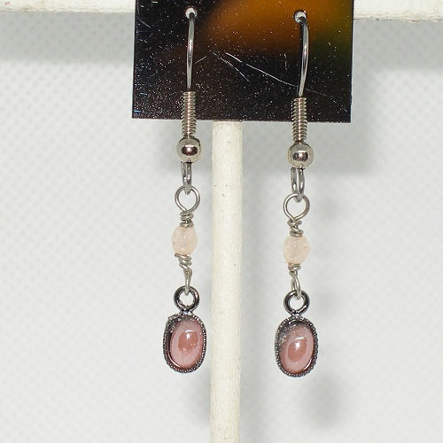 Pair of earrings with pink stones on a white background