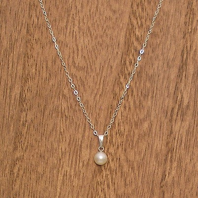Pearl necklace on a wooden surface