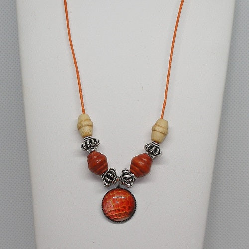 Necklace with red and beige beads on a white background