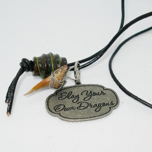 Necklace with pendant that says 'Slay Your Own Dragons' on a white background