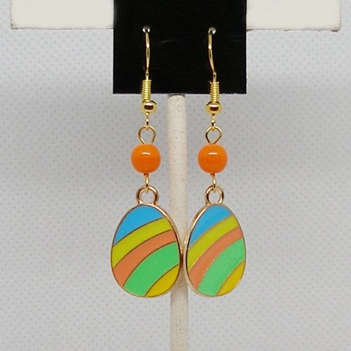 Colorful striped earrings with orange beads on a gray background