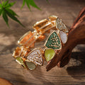 Artistic, colorful, and inspired by botanical details, the Enamel Leaf Bangle combines sculptural leaf motifs with glossy colored panels and warm gold-tone outlines. Its mix of triangular shapes, organic leaf detailing, and jewel-like shades creates a bold vintage-inspired look, while the elastic construction makes it easy and comfortable to slip on for everyday or occasion wear.