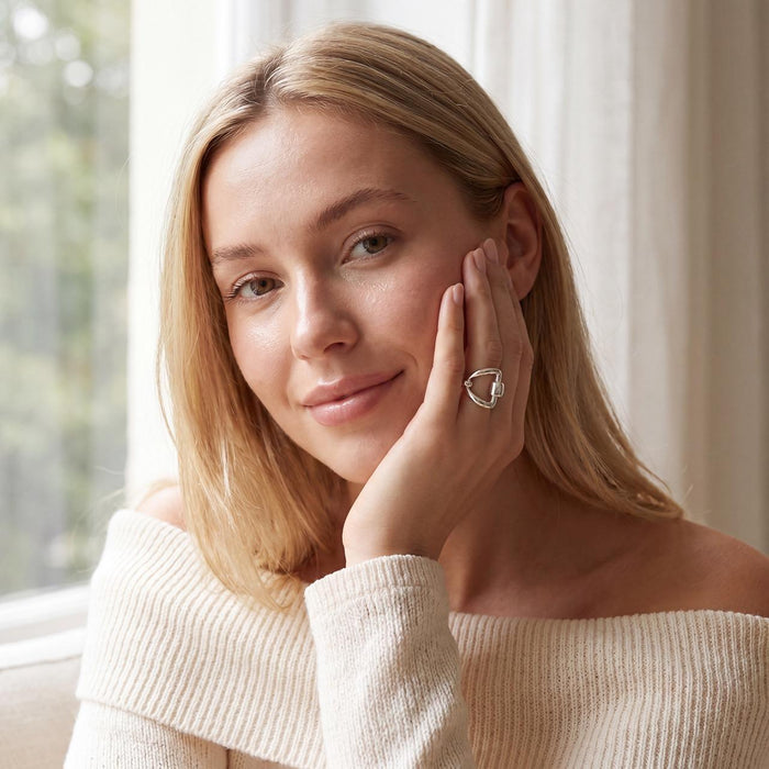 photo of a blond model wearing a silver equestrian themed ring