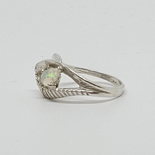 Silver ring with a gemstone on a light gray background