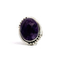 photo of a silver faceted oval amethyst ring with dots details in the frame on a white background front view