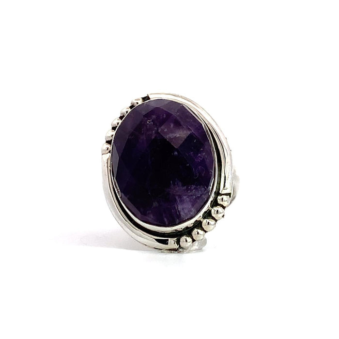 photo of a silver faceted oval amethyst ring with dots details in the frame on a white background front view