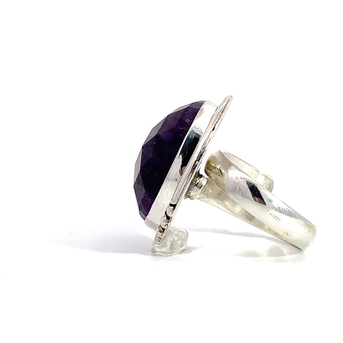photo of a silver faceted oval amethyst ring with dots details in the frame on a white background side view