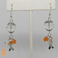 Earrings with orange and clear glass beads and Hope ribbon charms on a gray background