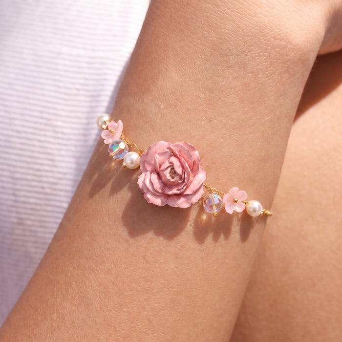 Cute, dreamy, and beautifully feminine, the Fairy Bloom Bracelet is made for someone who loves floral jewelry with a soft fairytale-inspired touch. Designed with a detailed rose centerpiece, delicate flower charms, luminous pearl accents, and shimmering crystal-style beads, this bracelet brings a magical pastel glow that feels perfect for everyday styling, special moments, or thoughtful gifting.