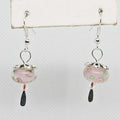 Pair of earrings with pink glass beads and silver hooks on a white background