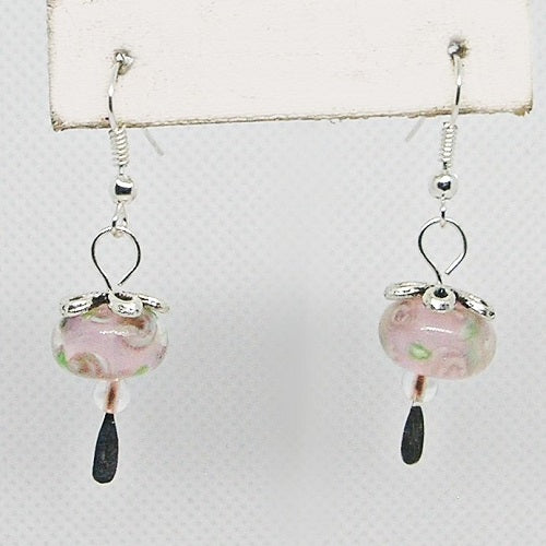 Pair of earrings with pink glass beads and silver hooks on a white background