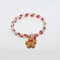 Bracelet with red and clear beads and a gingerbread man charm on a white background