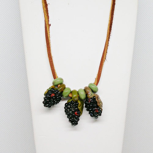Necklace with glass blackberries on a white background