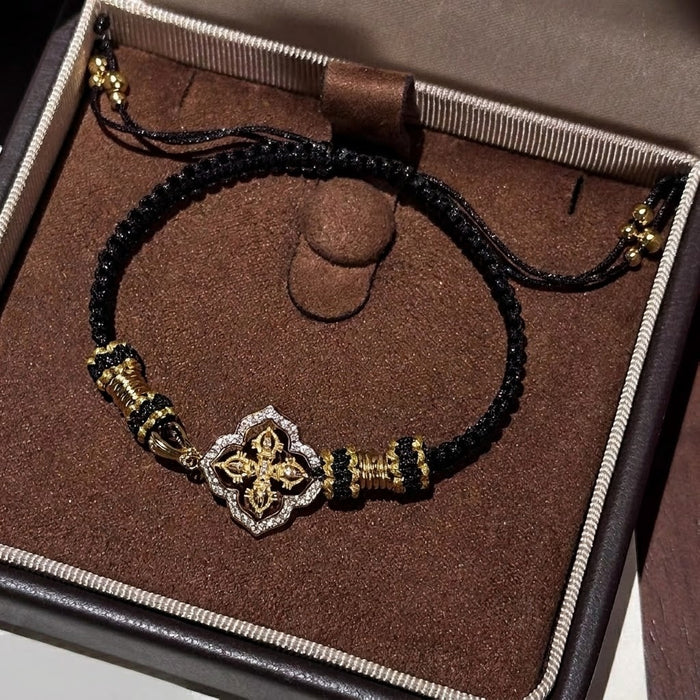 Elegant, bold, and full of refined detail, the Golden Clover Bracelet is a striking piece designed for someone who loves classic black and gold styling. Featuring a clover-inspired centerpiece with golden detailing and sparkling crystal-style accents, this bracelet brings a rich, polished look while the braided cord keeps it comfortable and easy to wear.