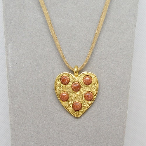 Gold heart-shaped pendant with brown stones on a gray background