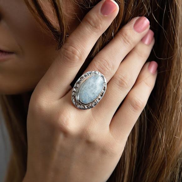 Photo of a brunette model wearing a silver oval white moonstone ring