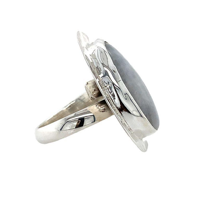 Photo of  a silver oval white moonstone ring on a white background Side view