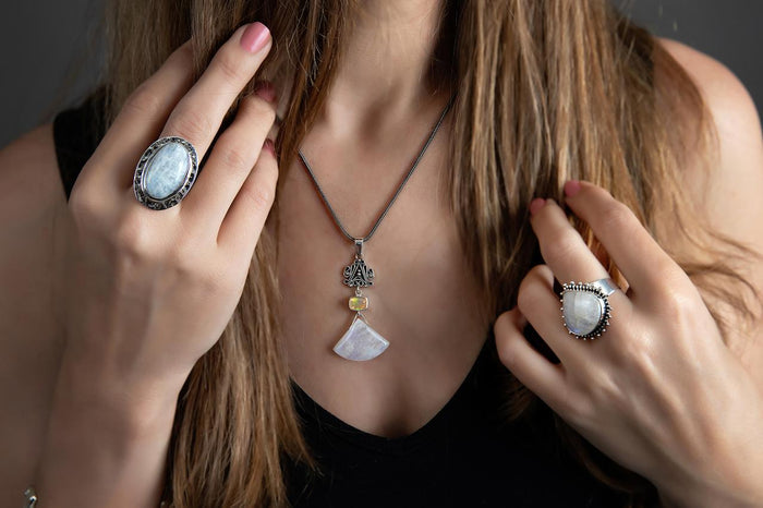 Photo of a brunette model wearing a silver oval white moonstone ring With other jewelry